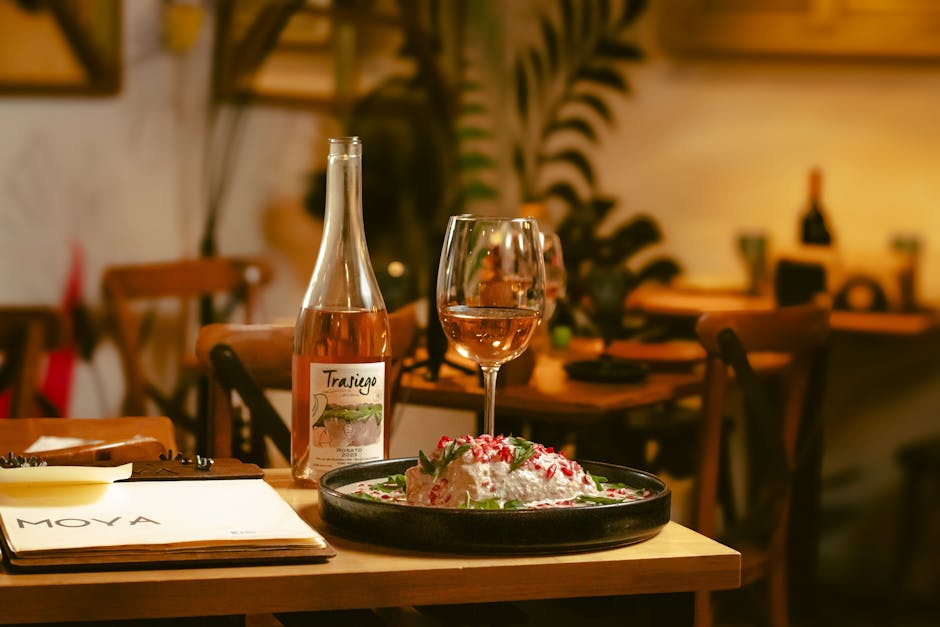 A sophisticated restaurant ambiance featuring rosé wine and a gourmet dish.